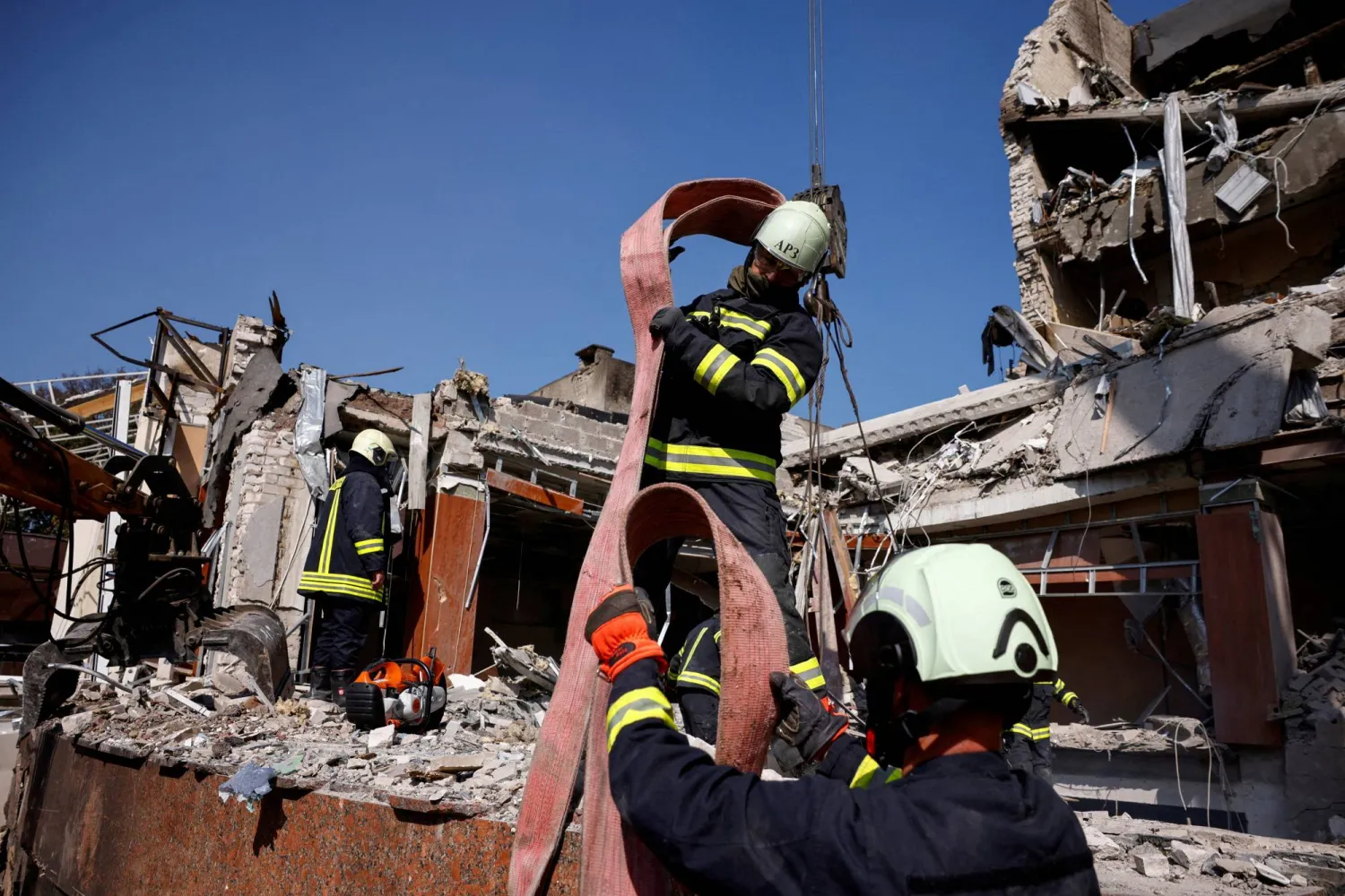 عمال الطوارئ يعملون في موقع فندق تعرض لأضرار بالغة خلال ضربة صاروخية روسية وسط الهجوم الروسي على أوكرانيا في تشيركاسي (رويترز)