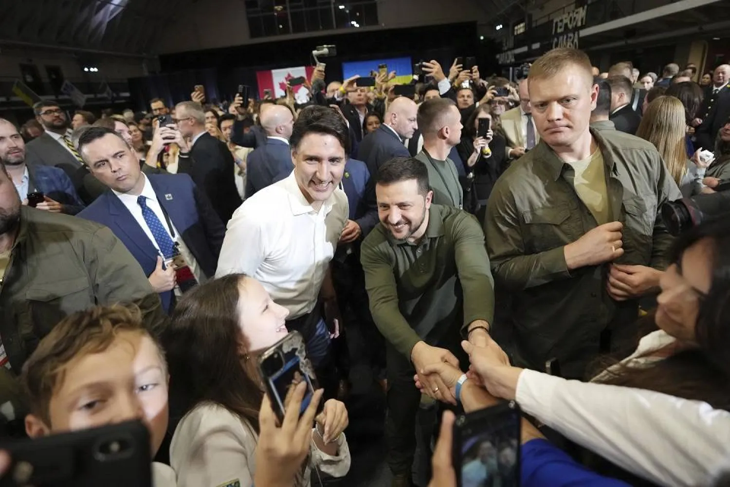 Prime Minister Justin Trudeau, center left, and Ukrainian President Volodymyr Zelenskyy, center right, greet supporters after a rally at the Fort York Armory in Toronto on Friday, Sept. 22, 2023. (The Canadian Press via AP) 