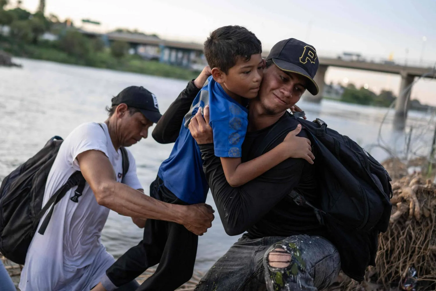 Migrants from Venezuela get out of the Rio Grande river as they climb the river bank at the US-Mexico border in Eagle Pass, Texas on September 23, 2023. (Photo by AFP)