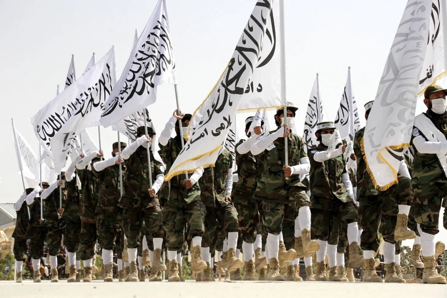 جنود من طالبان الأفغانية يسيرون حاملين الأعلام خلال حفل تخرجهم في مزار الشريف (أفغانستان) (إ.ب.أ)