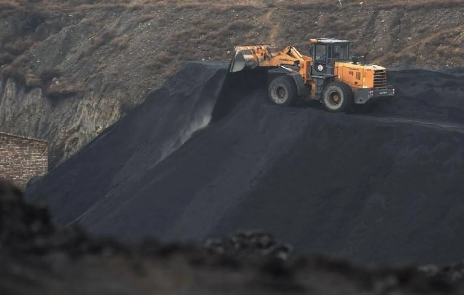 جرافة تقوم بإفراغ الفحم قرب منجم للفحم في الصين (أرشيفية - رويترز)