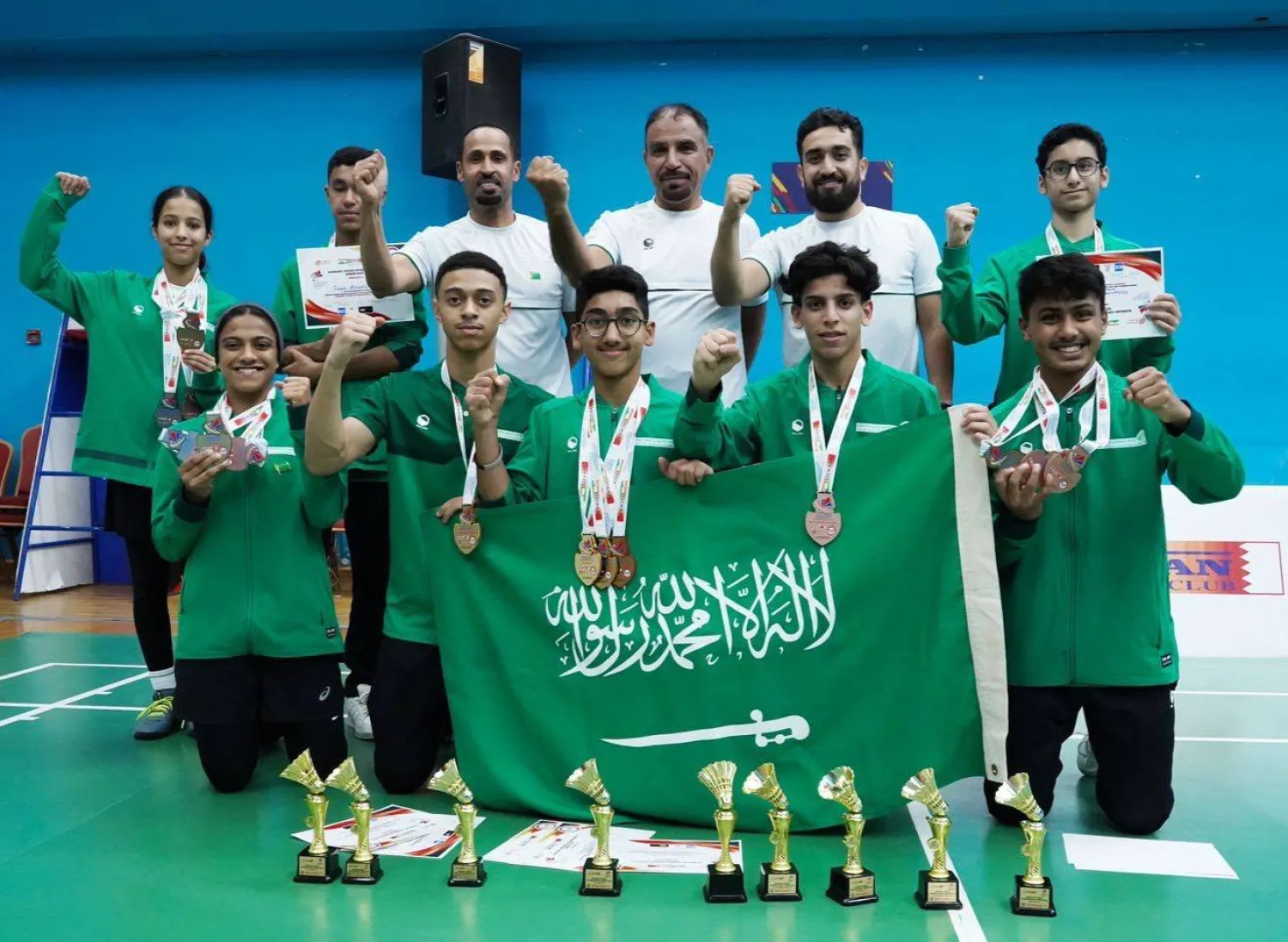 لاعبو ولاعبات المنتخب السعودي للريشة الطائرة في لقطة احتفالية بعد نهاية البطولة (الشرق الأوسط)