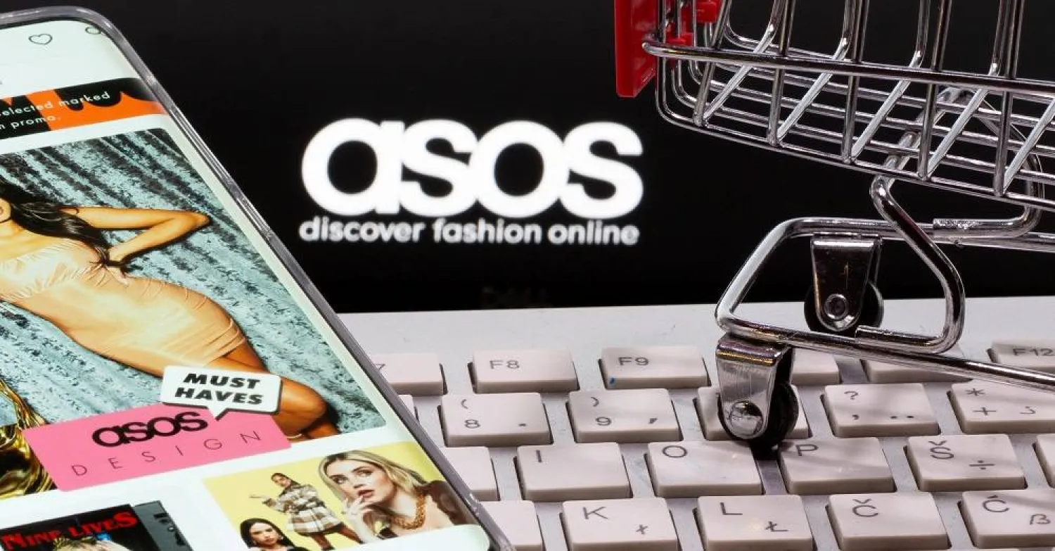  Smartphone with ASOS app, a keyboard and a shopping cart are seen in front of a displayed ASOS logo in this illustration picture taken October 13, 2020. (Reuters)
