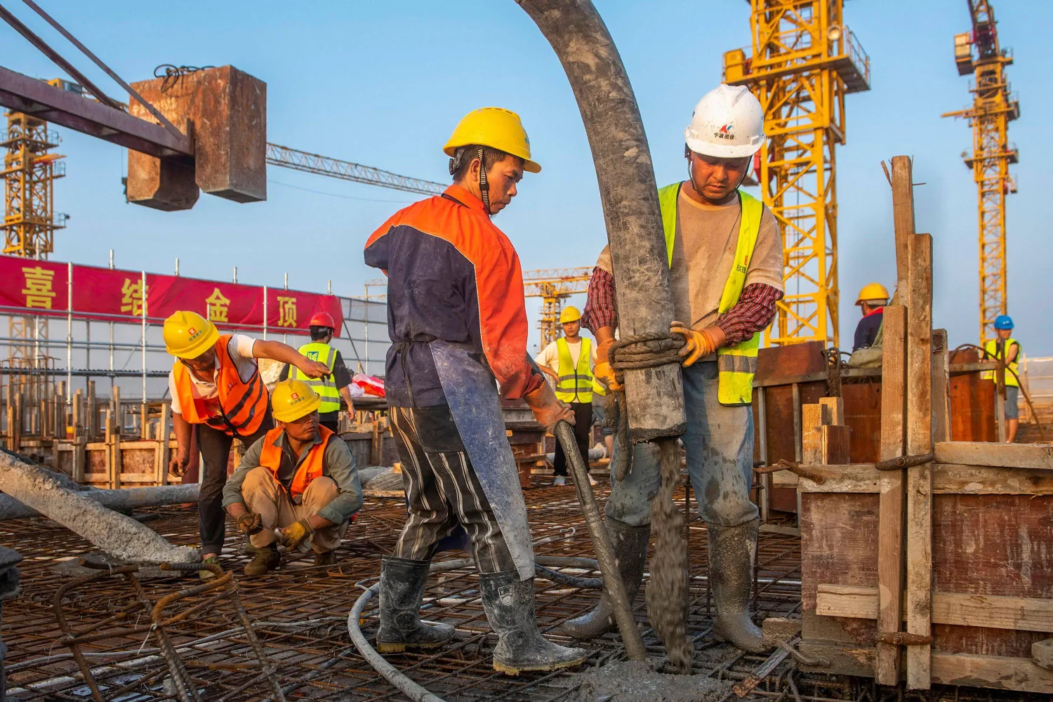 عمال في موقع بناء لمشروع إسكان في نينغبو بالصين (أ.ف.ب)