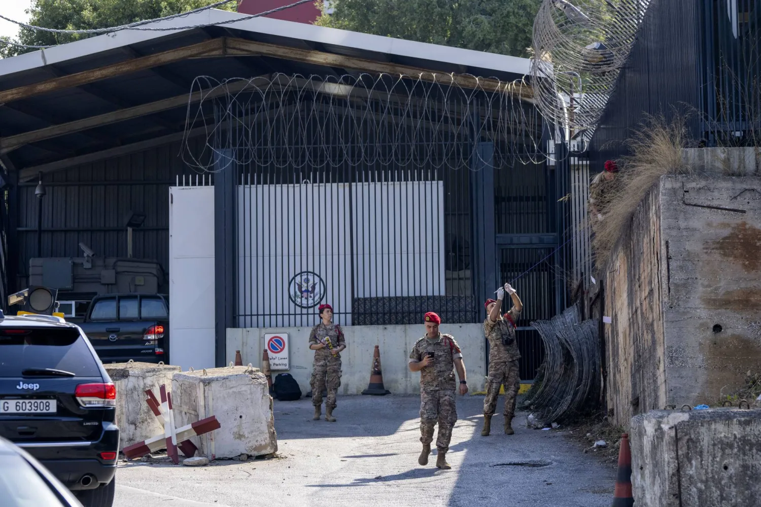 محققون من الجيش اللبناني يعاينون موقع إطلاق الرصاص على مدخل السفارة الأميركية في عوكر (أ.ب)