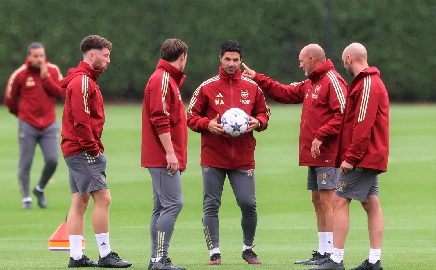 أرتيتا مدرب آرسنال ممسكاً بالكرة ويناقش مساعديه في إحدى الحصص التدريبية (رويترز)