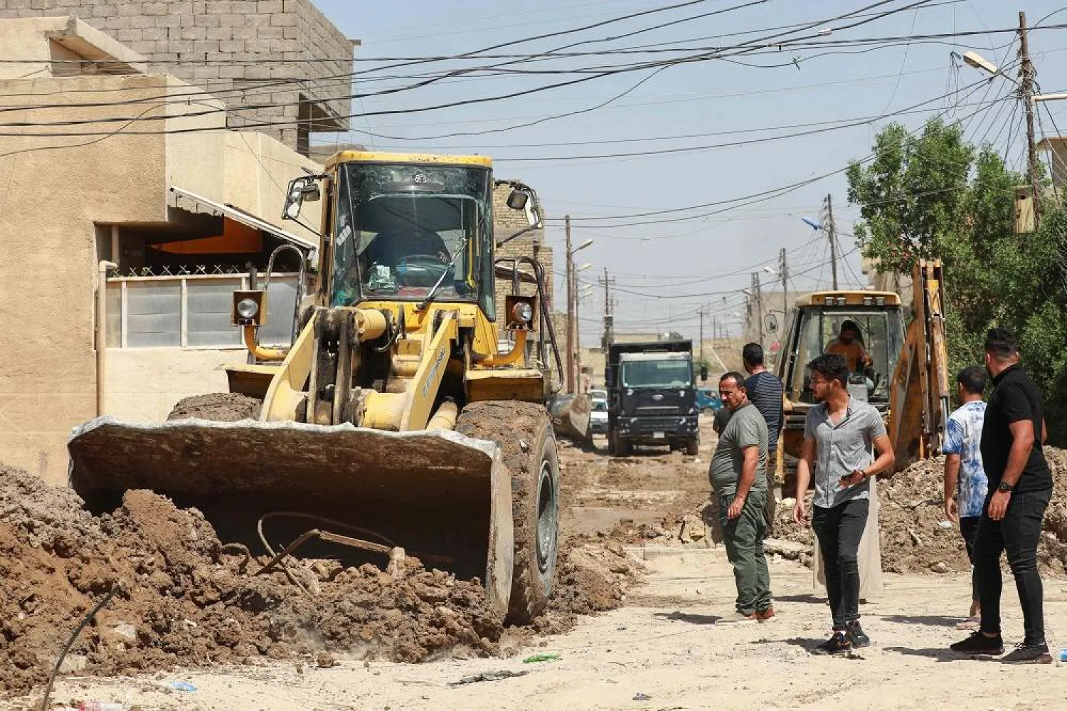 Workers rehabilitate a road as part of public works on the outskirts of Baghdad on September 15, 2023. (AFP)