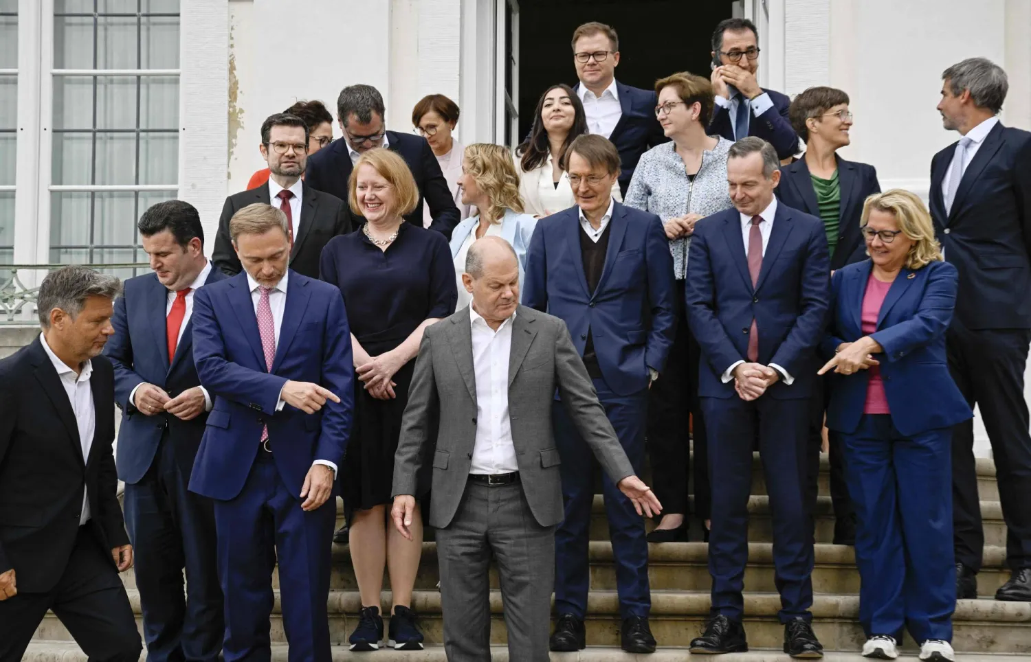 أولاف شولتس يتوسط الوزراء أثناء التقاط صورة جماعية في اليوم الثاني من اجتماع لمجلس الوزراء الألماني في قصر ميسبيرغ (أ.ف.ب)