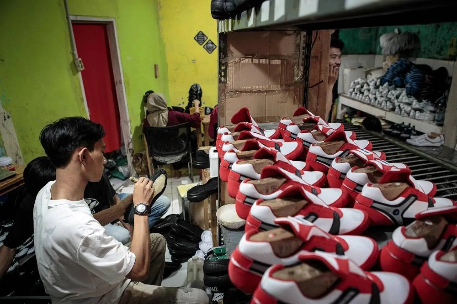 A staff of a small shoe manufacturer makes their new products as they make an introductory video to be posted on social media in Bogor, West Java, on 27 September 2023. (AFP)