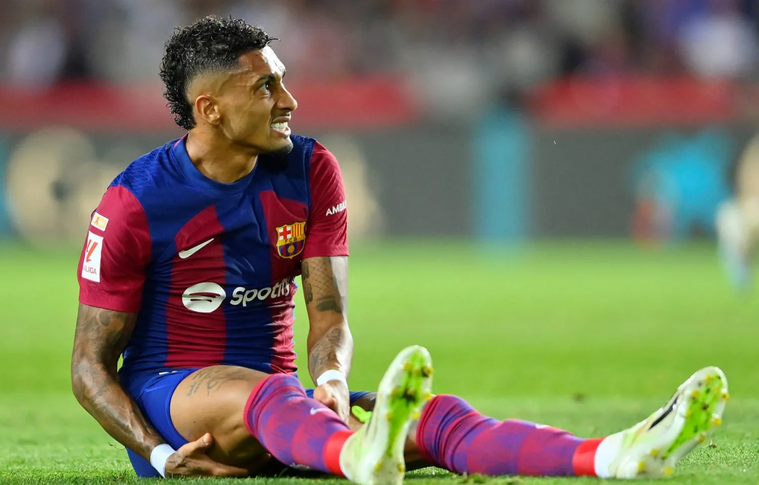 رافينيا خلال تعرضه للإصابة في مواجهة إشبيلية (أ.ف.ب)