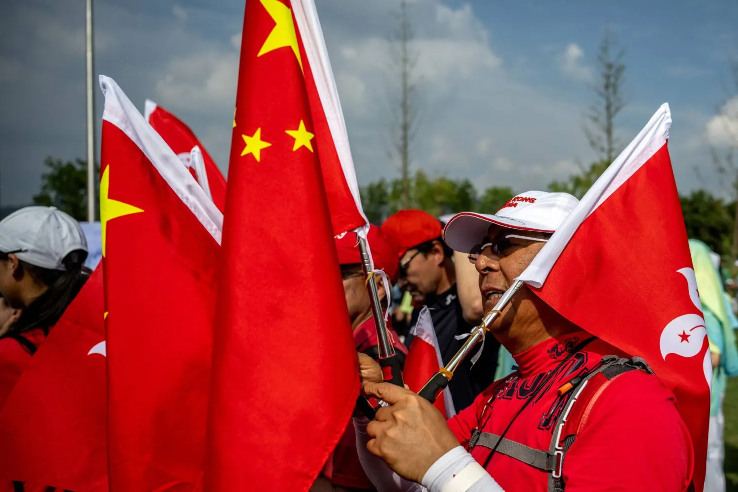 متفرج يحمل الأعلام الوطنية الصينية وعلم هونغ كونغ في دورة الألعاب الآسيوية هانغتشو 2022 بمقاطعة تشيجيانغ شرق الصين (وكالة الصحافة الفرنسية)