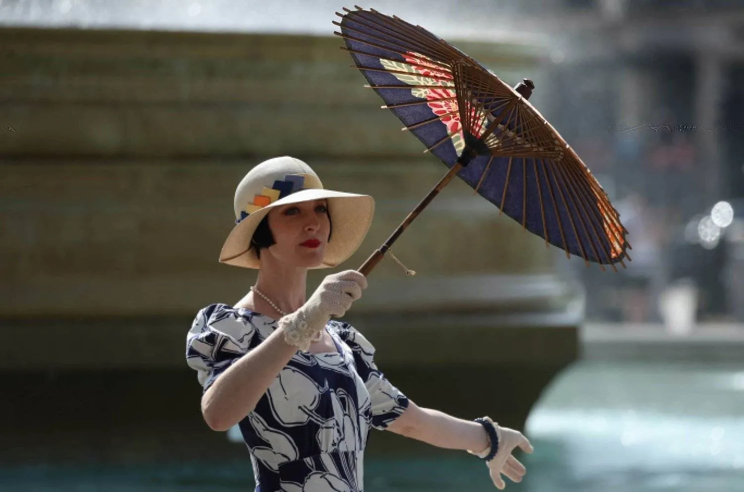 امرأة تستخدم مظلة ورقية لحماية نفسها من أشعة الشمس في لندن- بريطانيا 5 سبتمبر 2023 (إ.ب.أ)