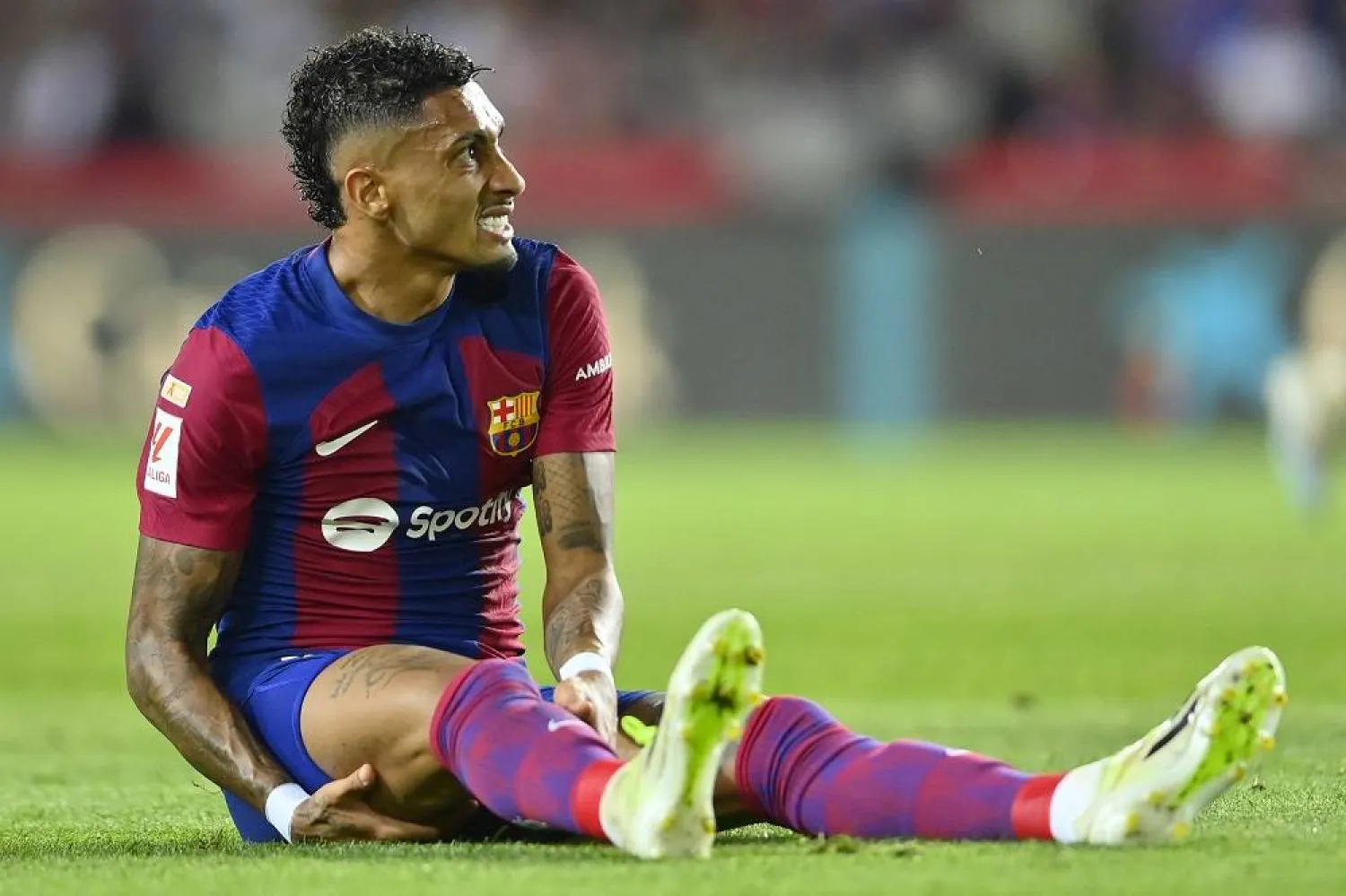 Barcelona's Brazilian forward #11 Raphinha sits on the field during the Spanish Liga football match between FC Barcelona and Sevilla FC at the Estadi Olimpic Lluis Companys in Barcelona on September 29, 2023. (AFP)