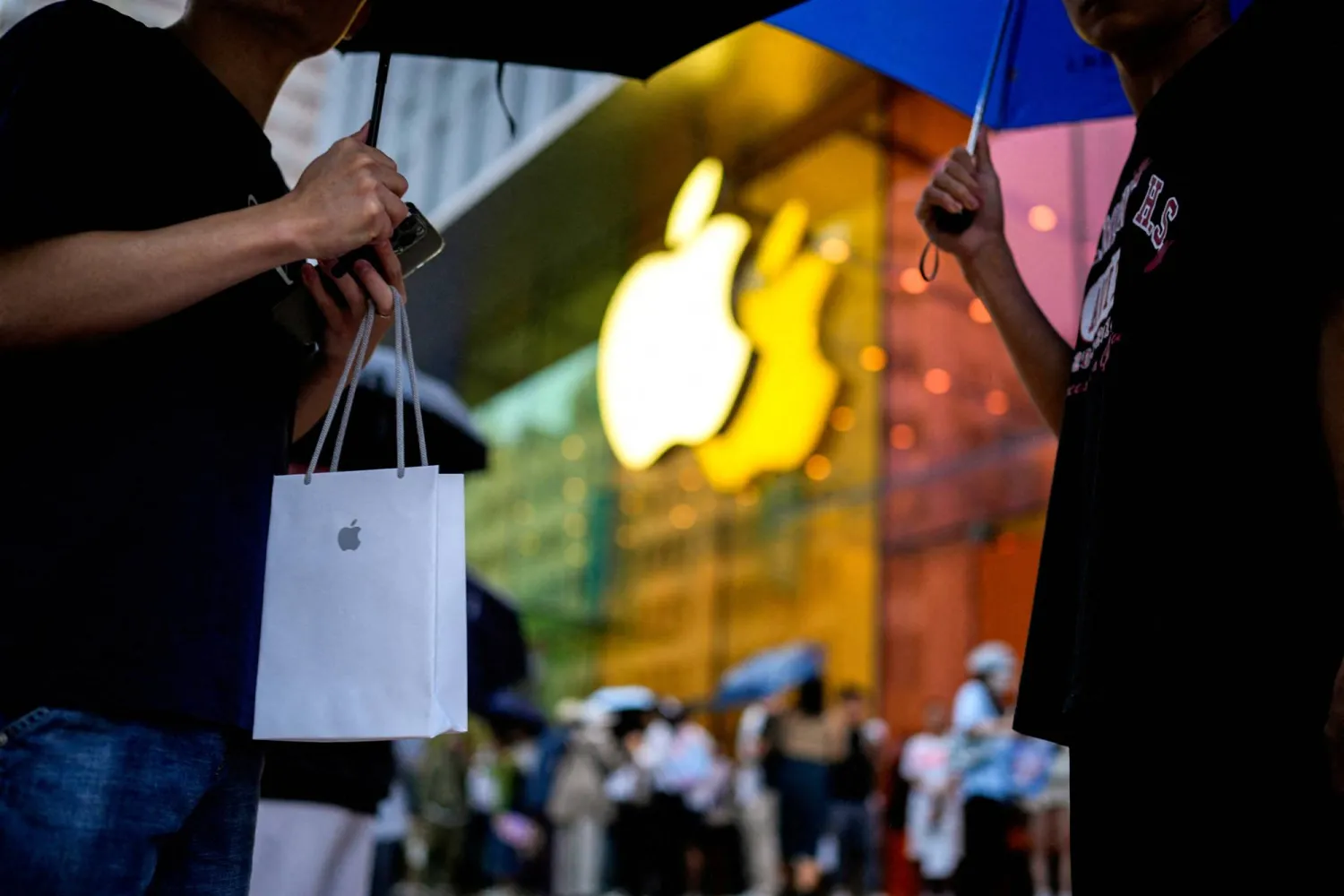 FILE PHOTO: A man holds a bag with a new iPhone inside as Apple's new iPhone 15 officially goes on sale across China, next to an Apple Store, in Shanghai, China September 22, 2023. REUTERS/Aly Song/File Photo