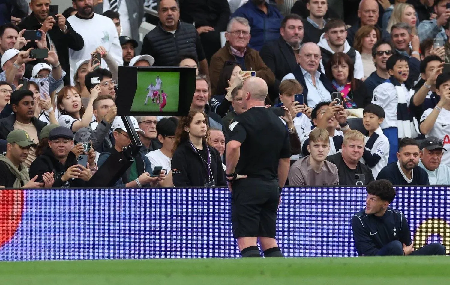 الحكم سيمون هوبر يراجع تقنية الفيديو خلال إدارته لمباراة توتنهام وليفربول (إ.ب.أ) 