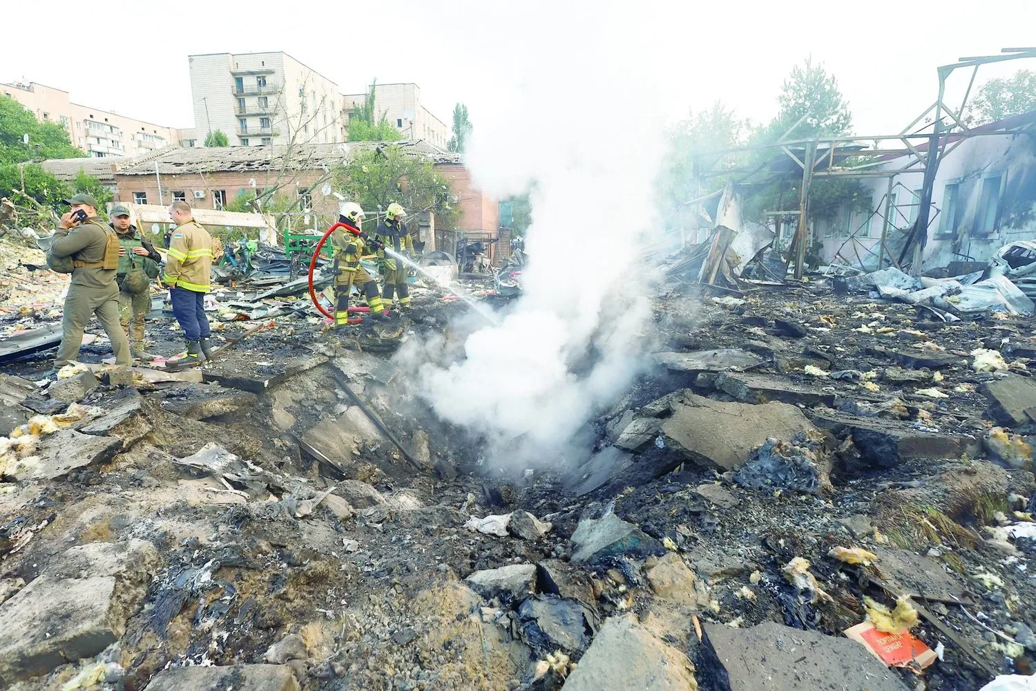 Bir itfaiyeci, Rusya'nın Kiev'de Ukrayna'ya saldırısı sırasında Rus füze saldırısı sırasında hasar gören bir yerleşim bölgesinde çalışıyor (Reuters)