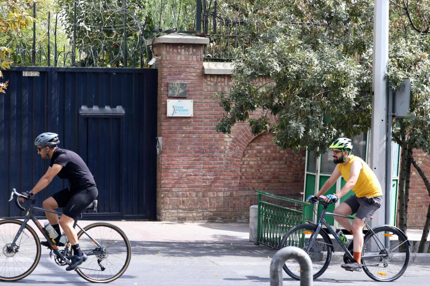 أشخاص يركبون الدراجات أمام المدرسة الفرنسية في شمال طهران 3 أكتوبر 2023 (أ.ف.ب)