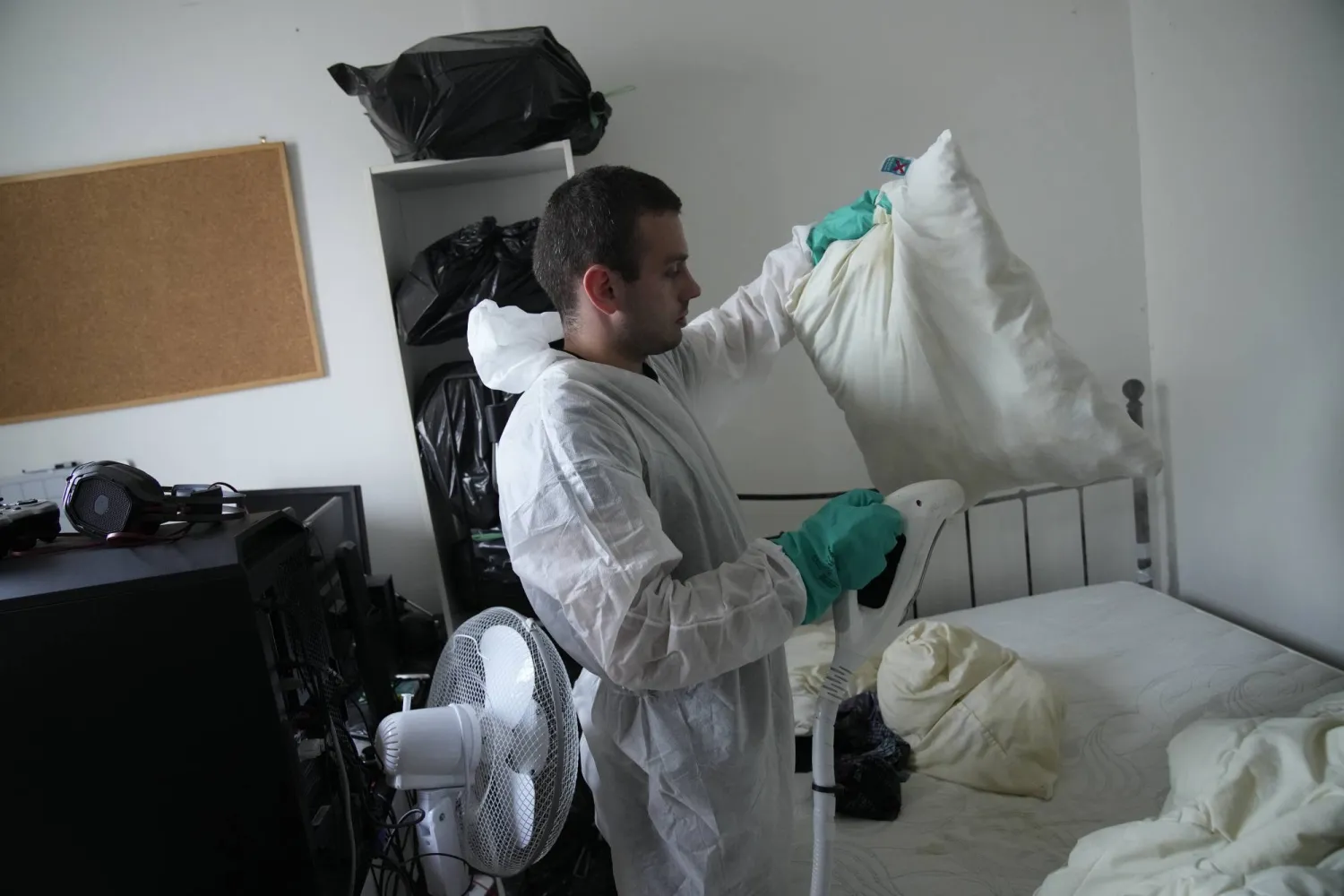 Pest control technician Lucas Pradalier sprays steam on a pillow in a Paris apartment, Wednesday, Oct. 4, 2023. (AP Photo/Christophe Ena)