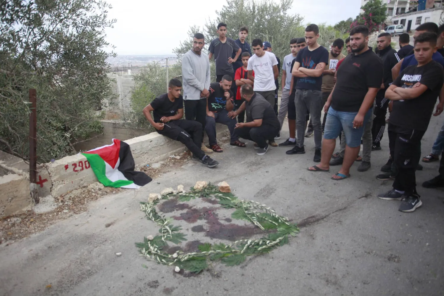 فلسطينيون حول بقع من الدم في طولكرم (د.ب.أ)