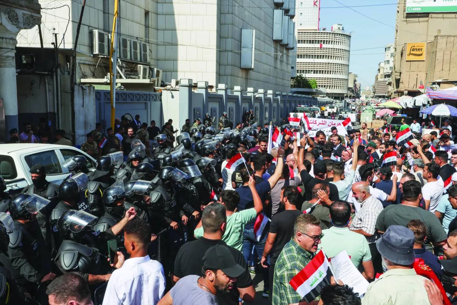 
أصحاب شركات الصرافة يتظاهرون أمام البنك المركزي العراقي مطالبين برفع القيود المفروضة عليهم في بغداد أمس (رويترز)