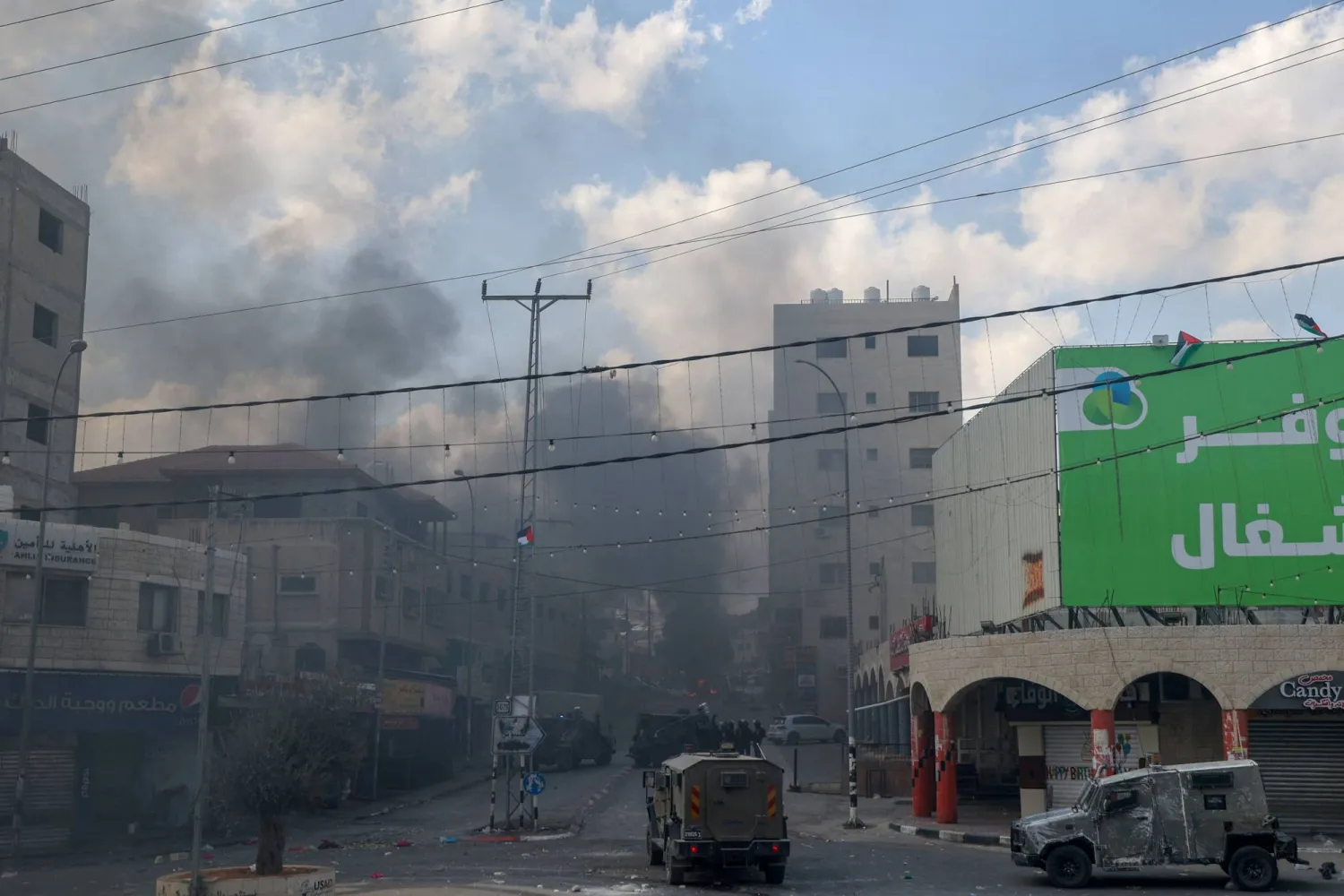 دخان يتصاعد خلال مواجهات بين جنود إسرائيليين وفلسطينيين في حوارة بالضفة الغربية الجمعة (أ.ف.ب)