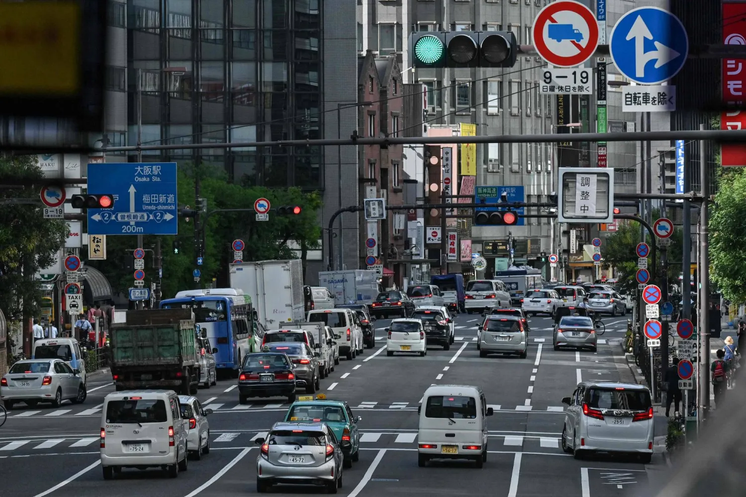This photo taken on September 14, 2023 shows traffic waiting for the lights to change in downtown Osaka. (Photo by Richard A. Brooks / AFP)