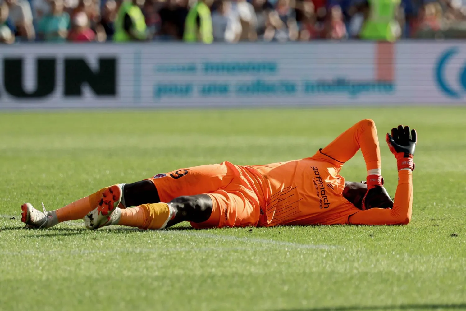 Clermont-Ferrand's French goalkeeper #99 Mory Diaw injured by a firecracker lies on the ground during the French L1 football match between Montpellier Herault SC and Clermont foot 63 at Stade de la Mosson in Montpellier, southern France on October 8, 2023. (Photo by Pascal GUYOT / AFP)