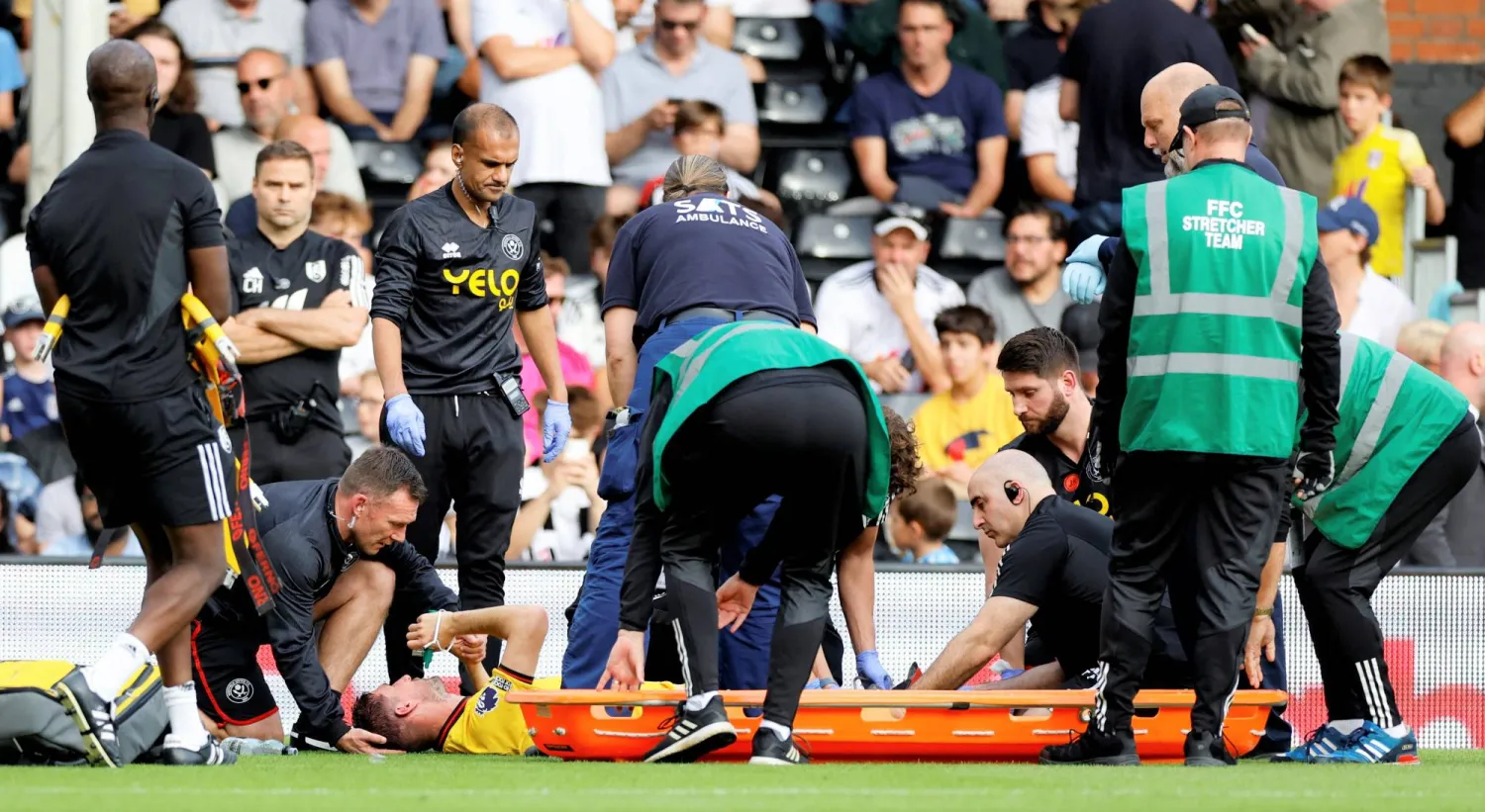 كريس باشام قائد شيفيلد يتلقى الرعاية الطبية الأولية خلال مواجهة فولهام قبل نقله للمستشفى (رويترز)