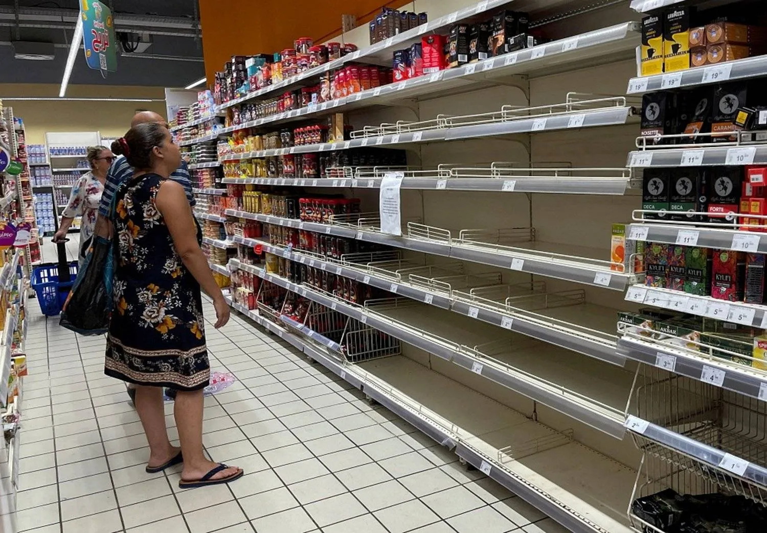 A customer stands in front of empty shelves for some coffee products inside a supermarket in Tunis, Tunisia September 3, 2022. (Reuters)
