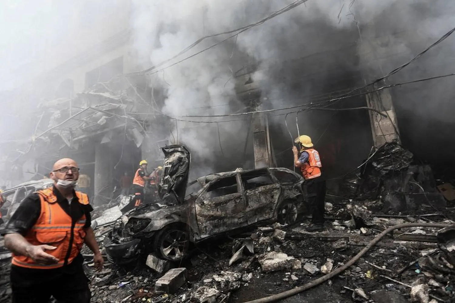 Palestinian rescuers work at the site of Israeli strikes, in Jabalia refugee camp, in the northern Gaza Strip October 9, 2023. (Reuters)