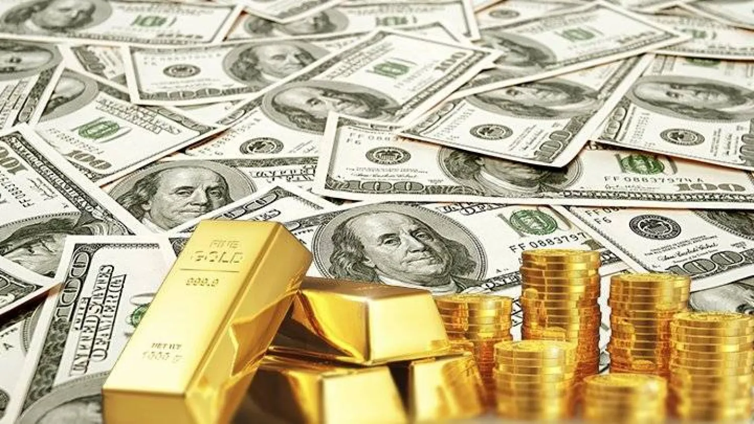 سبائك وعملات من الذهب على فئات نقدية من الدولار (رويترز)