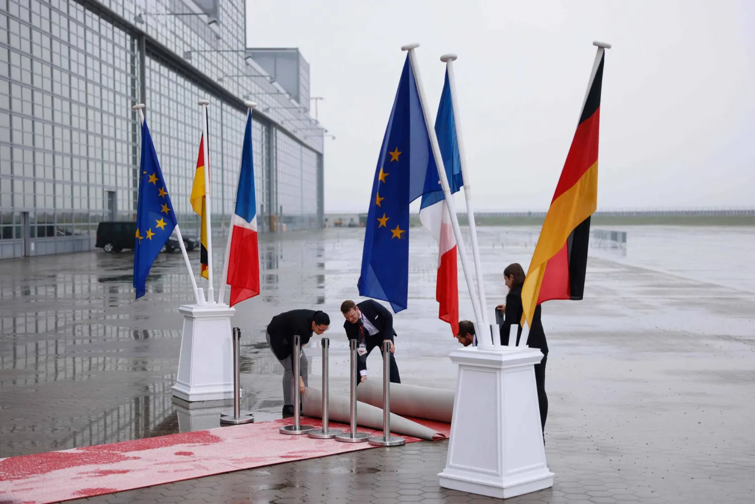 رفع علمي ألمانيا وفرنسا في مطار هامبورغ قبيل وصول الرئيس الفرنسي إيمانويل ماكرون الاثنين (أ.ف.ب)