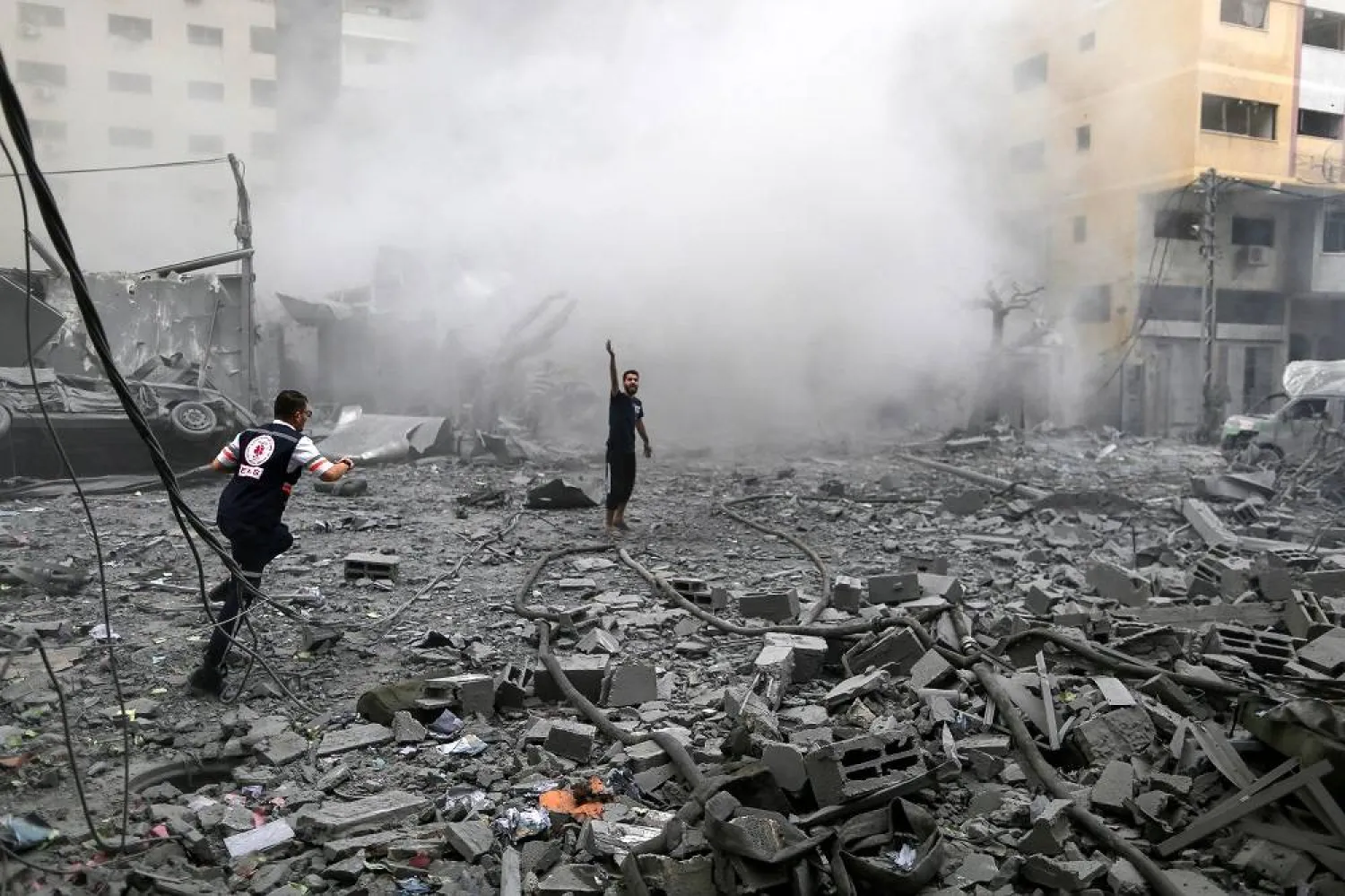  Palestinians stand among rubble following Israeli strikes on a residential building, in Gaza City, October 9, 2023. (Reuters)