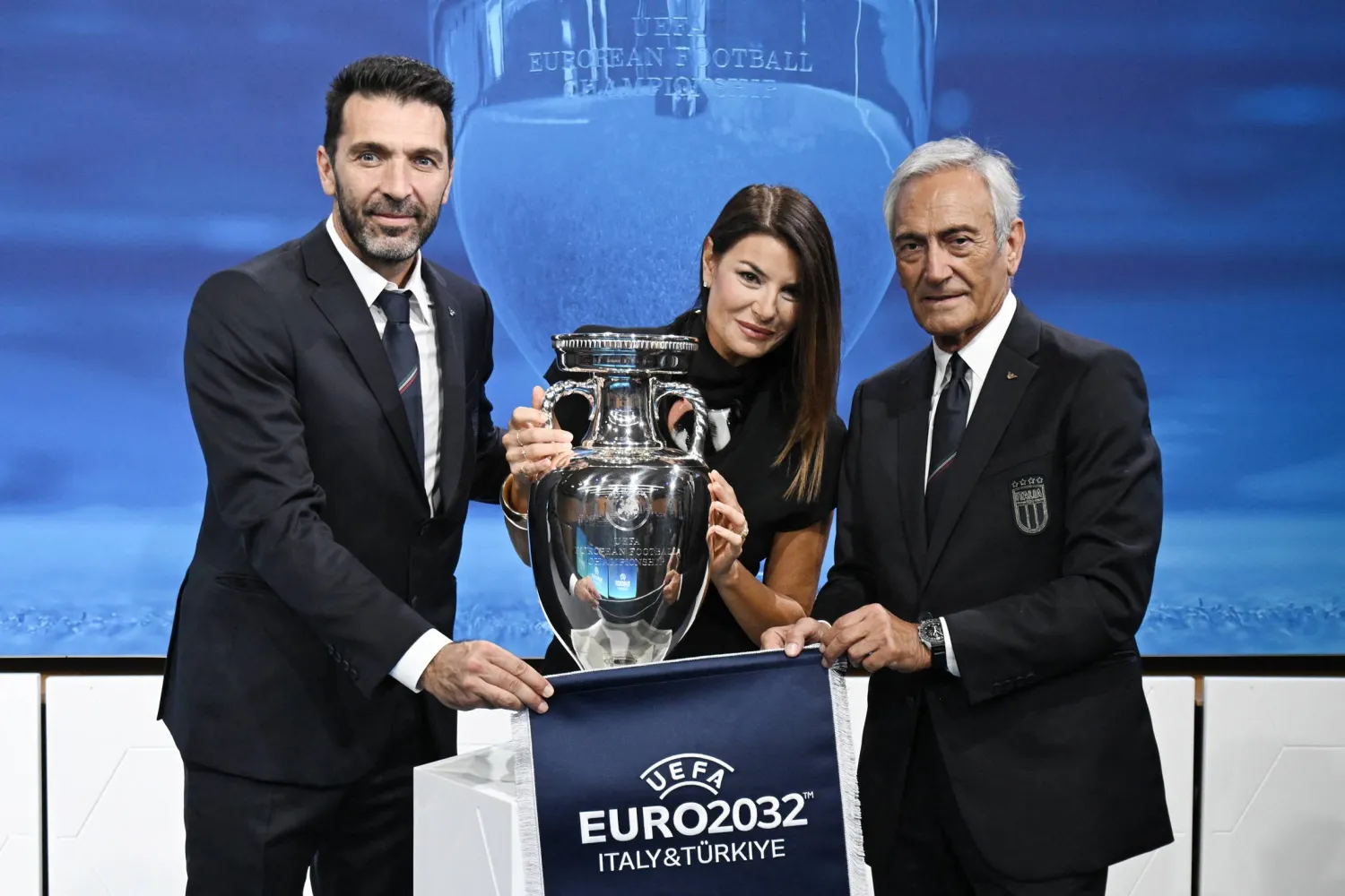 غابرييل غرافينا (يمين) والحارس المخضرم بوفون (يسار) يحملان الكأس والراية بعد انتخاب إيطاليا لاستضافة بطولة يورو 2032 (أ.ف.ب)