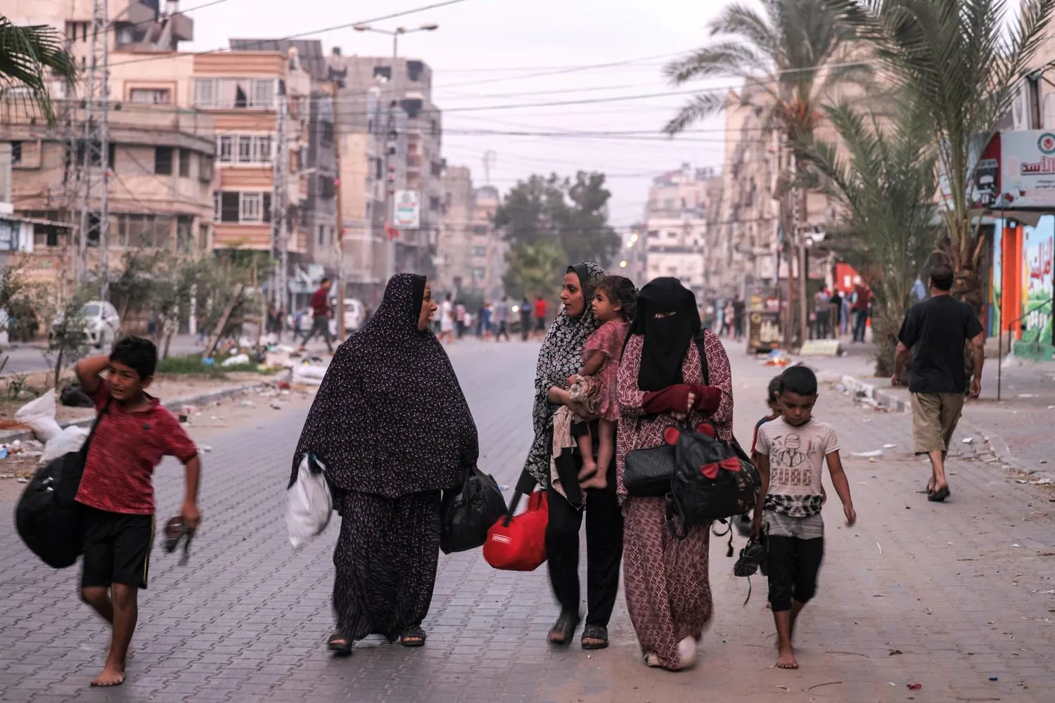 Kadınlar ve çocukları Gazze'de bir sokağa bomba atılmasından kaçıyor (AFP)