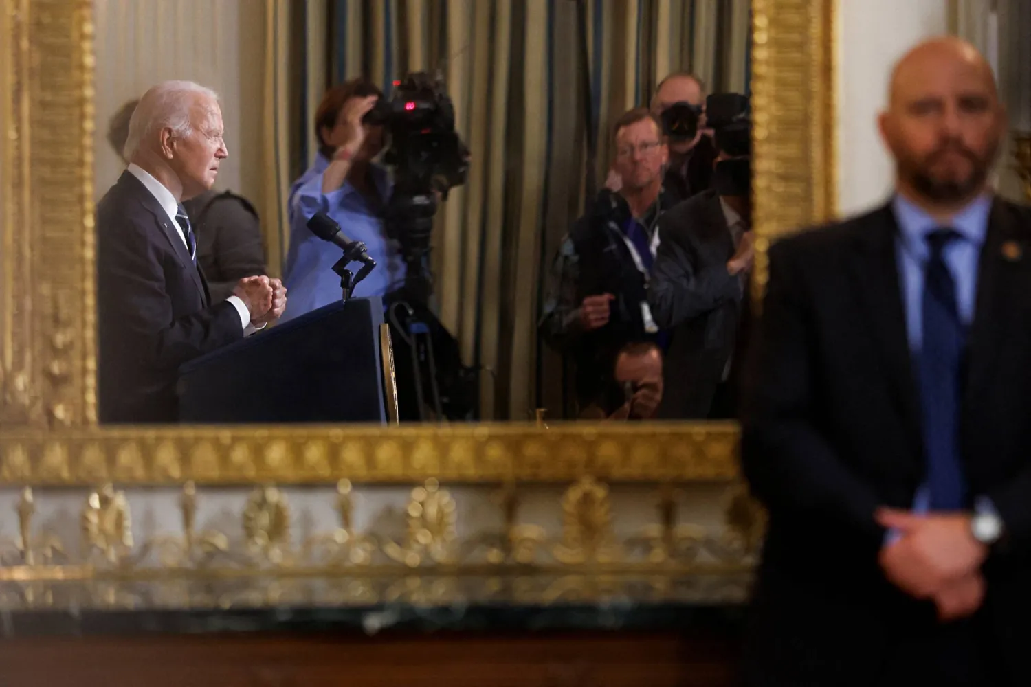 صورة الرئيس بايدن في المرآة وهو يدلي بتصريحات حول الوضع في إسرائيل مساء الثلاثاء (رويترز)