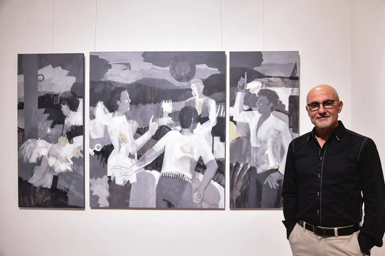 مازجي أمام إحدى لوحاته بتدرّجات الأبيض والأسود (غاليري آرت أون 56)