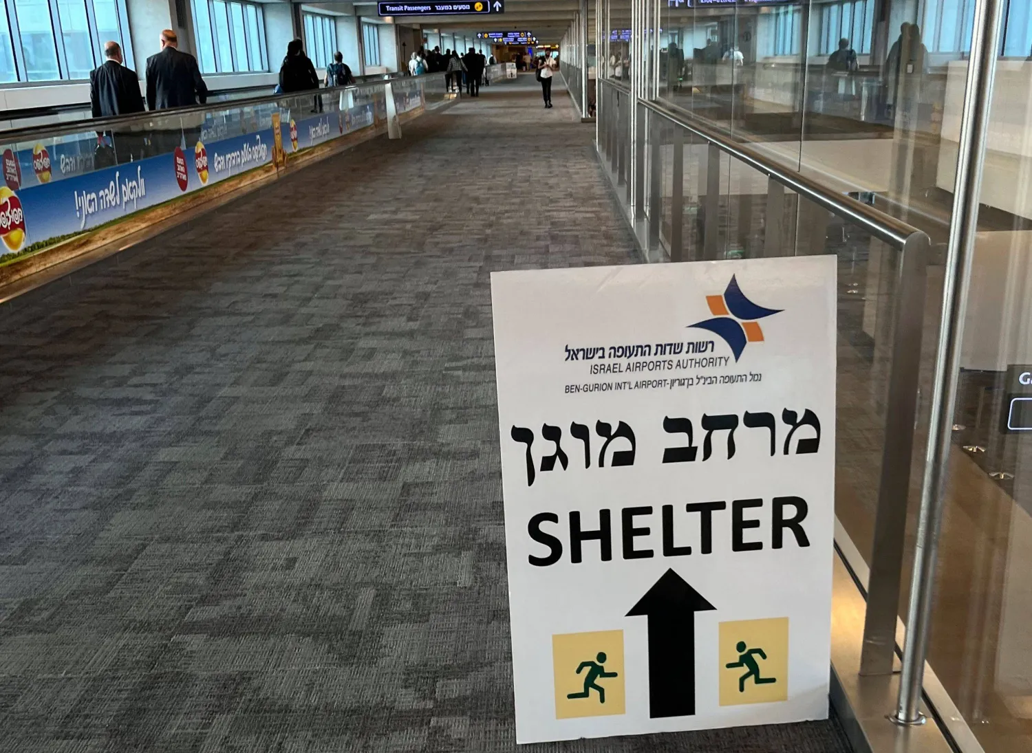 A sign informing passengers about the location of rocket shelters is set-up in a hallway as travelers arrive at Ben Gurion International Airport near Tel Aviv on October 10, 2023. (Photo by Yuri CORTEZ / AFP)