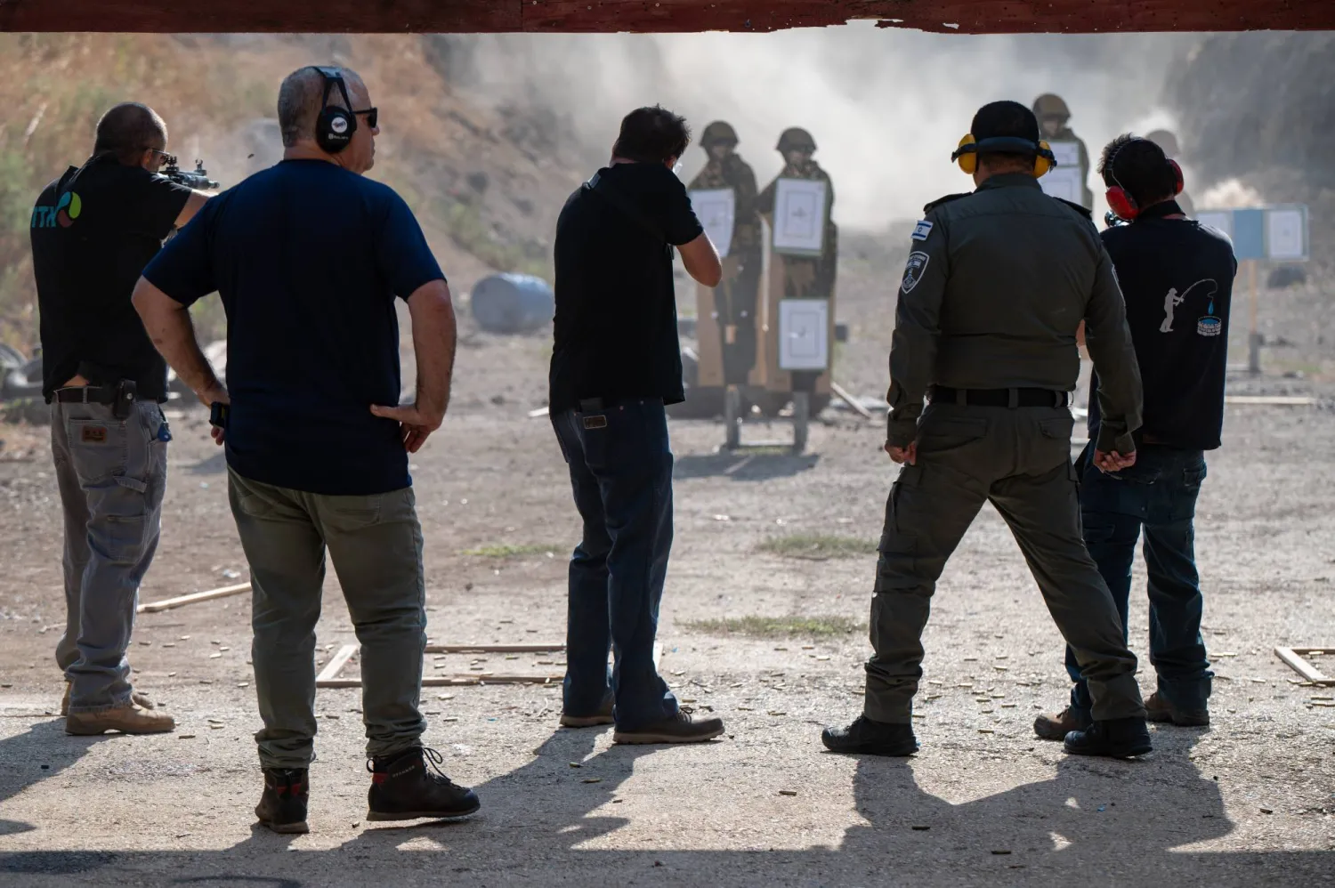 مدنيون إسرائيليون يخضعون للتدريب بعد تلقي الأسلحة في شمال إسرائيل بالقرب من الحدود مع لبنان (إ.ب.أ)