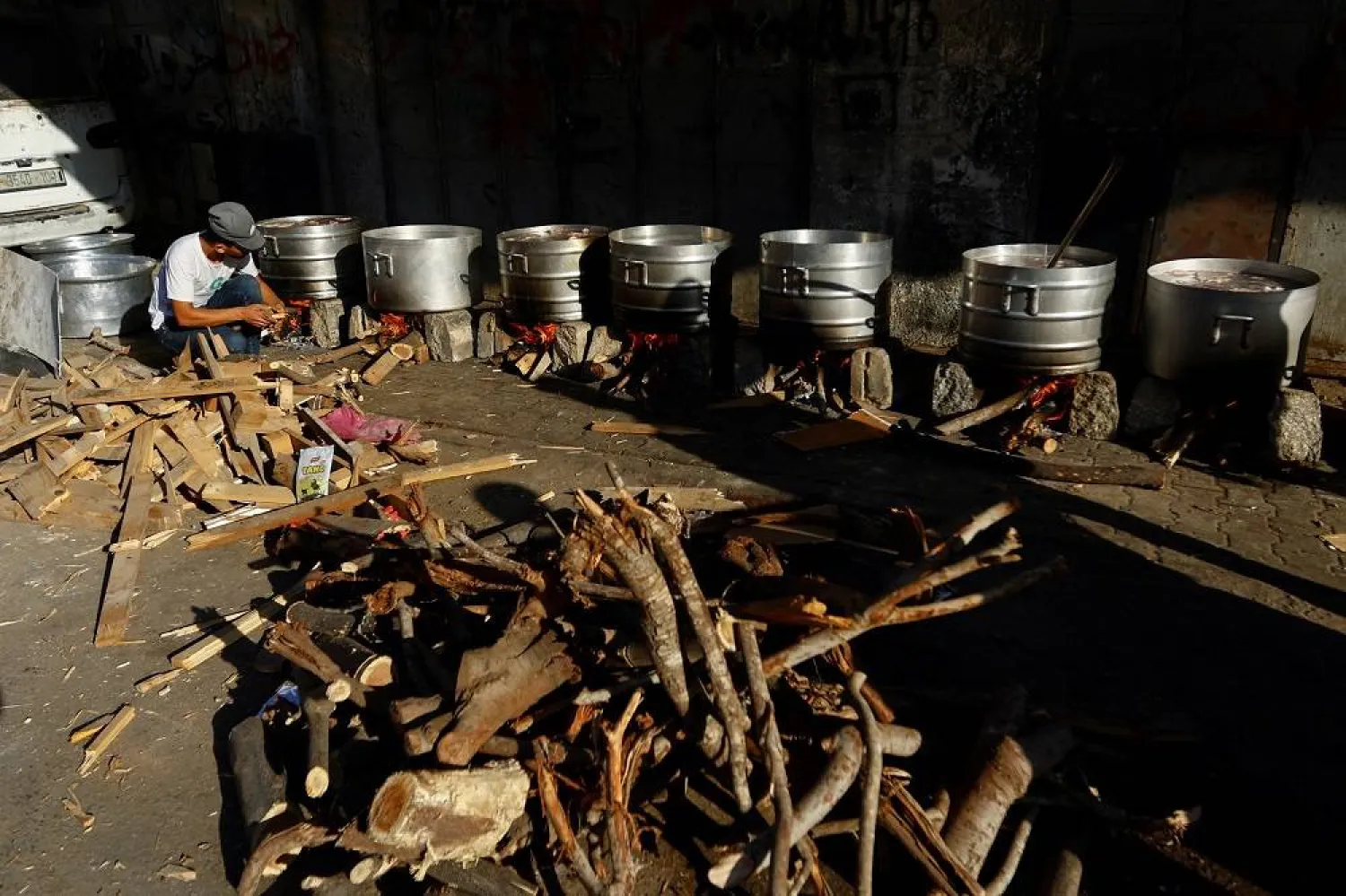 People cook on firewood amid shortages of fuel and gas to provide food for Palestinians who fled their houses amid Israeli strikes in Khan Younis, in the southern Gaza Strip October 15, 2023. (Reuters)