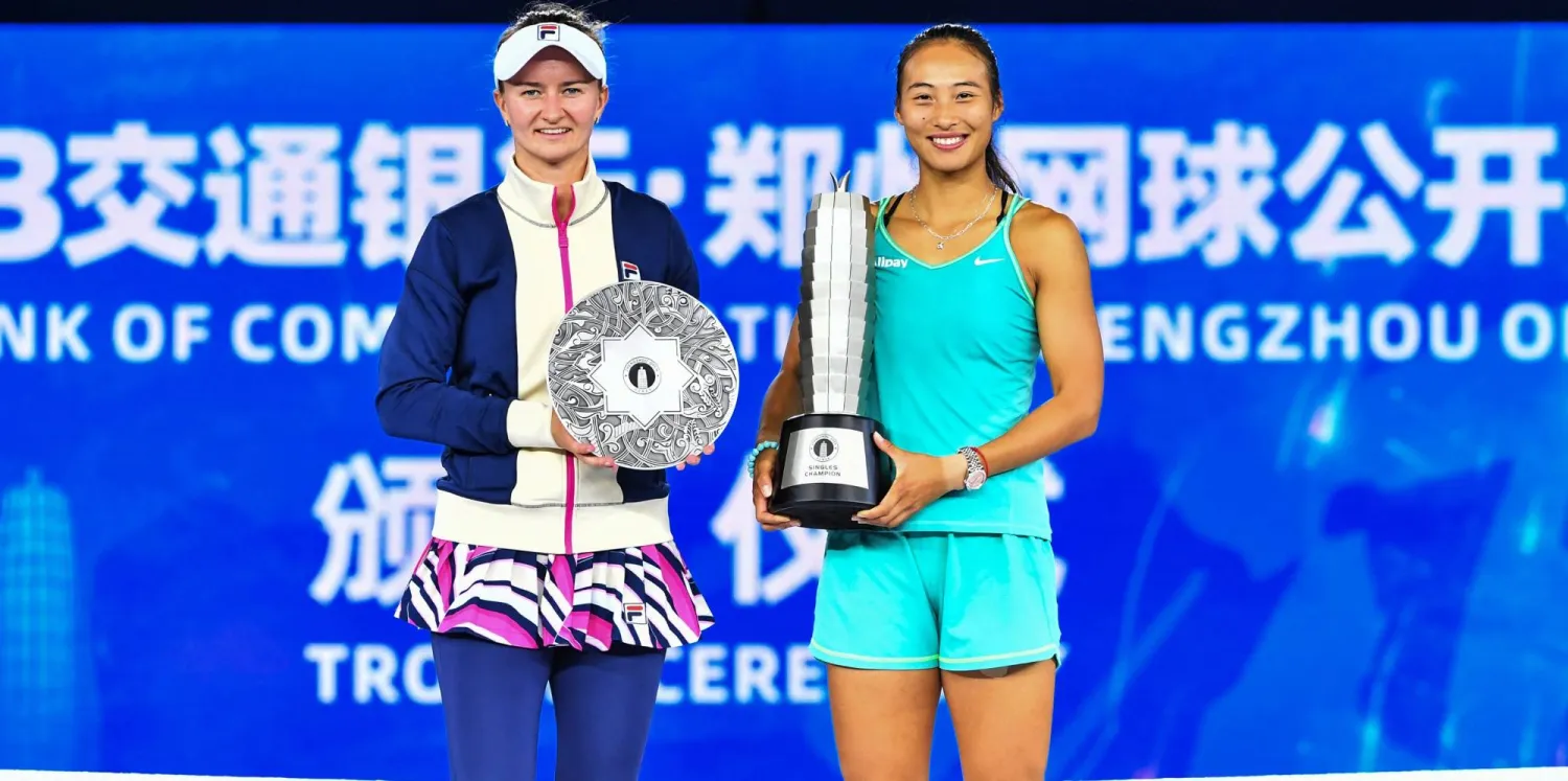 الصينية تشينوين تحمل كأس بطولة تشنغتشو بعد فوزها على كرايتشيكوفا التي تظهر بجوارها تحمل جائزة المركز الثاني (أ.ف.ب)