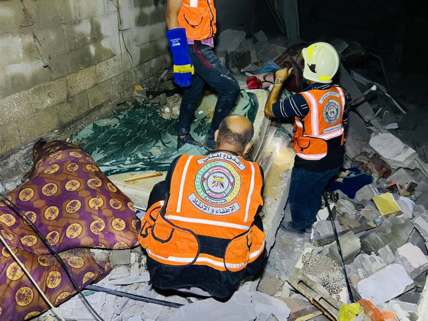 أفراد الدفاع المدني في غزة يعملون على إخراج المصابين وضحايا القصف من تحت الركام (الداخلية في غزة)