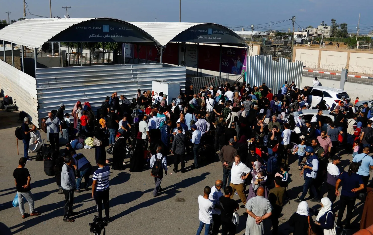 Çifte vatandaşlığa sahip Filistinliler, bugün Gazze'den ayrılma izni almak umuduyla Mısır ile Refah sınır kapısı dışında toplanıyor (Reuters)