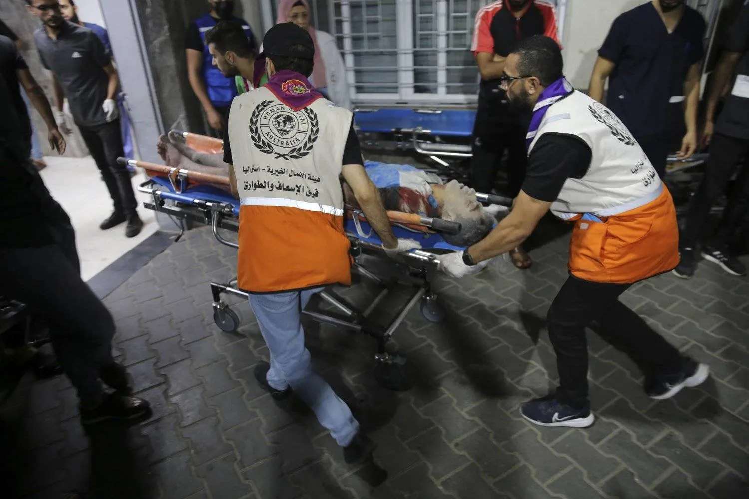 مسعفون يدخلون جريحاً إلى مستشفى «الشفاء» في غزة (أ.ب)