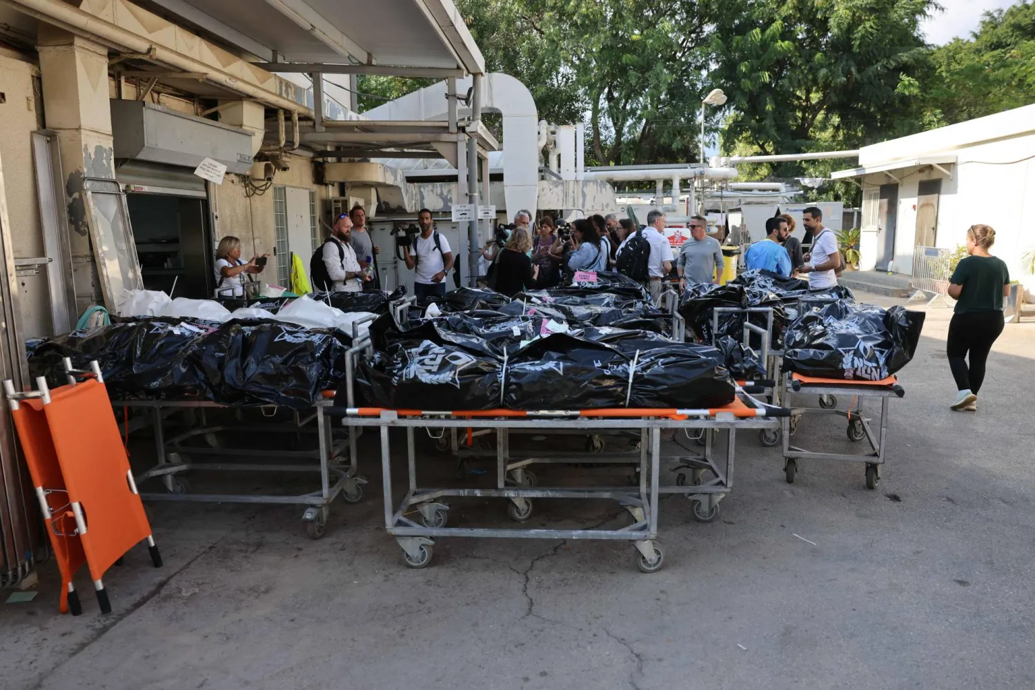 جثث إسرائيليين من ضحايا هجوم حركة «حماس» على جنوب إسرائيل خارج مركز الطب الشرعي في تل أبيب (أ.ف.ب)