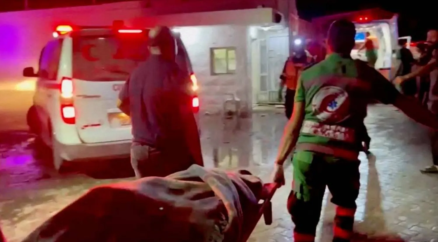 Rescue personnel work at scene At Al-Ahli Hospital, after hundreds of Palestinians were killed in a blast at Al-Ahli hospital in Gaza that Israeli and Palestinian officials blamed on each other in Gaza City, Gaza Strip, in this screen grab obtained from video, October 17, 2023. (Reuters/Reuters TV)