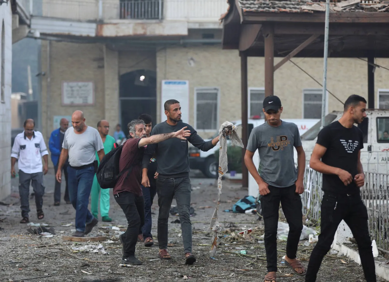 أشخاص يتفقدون محيط مستشفى «الأهلي المعمداني» في غزة صباح اليوم (رويترز)