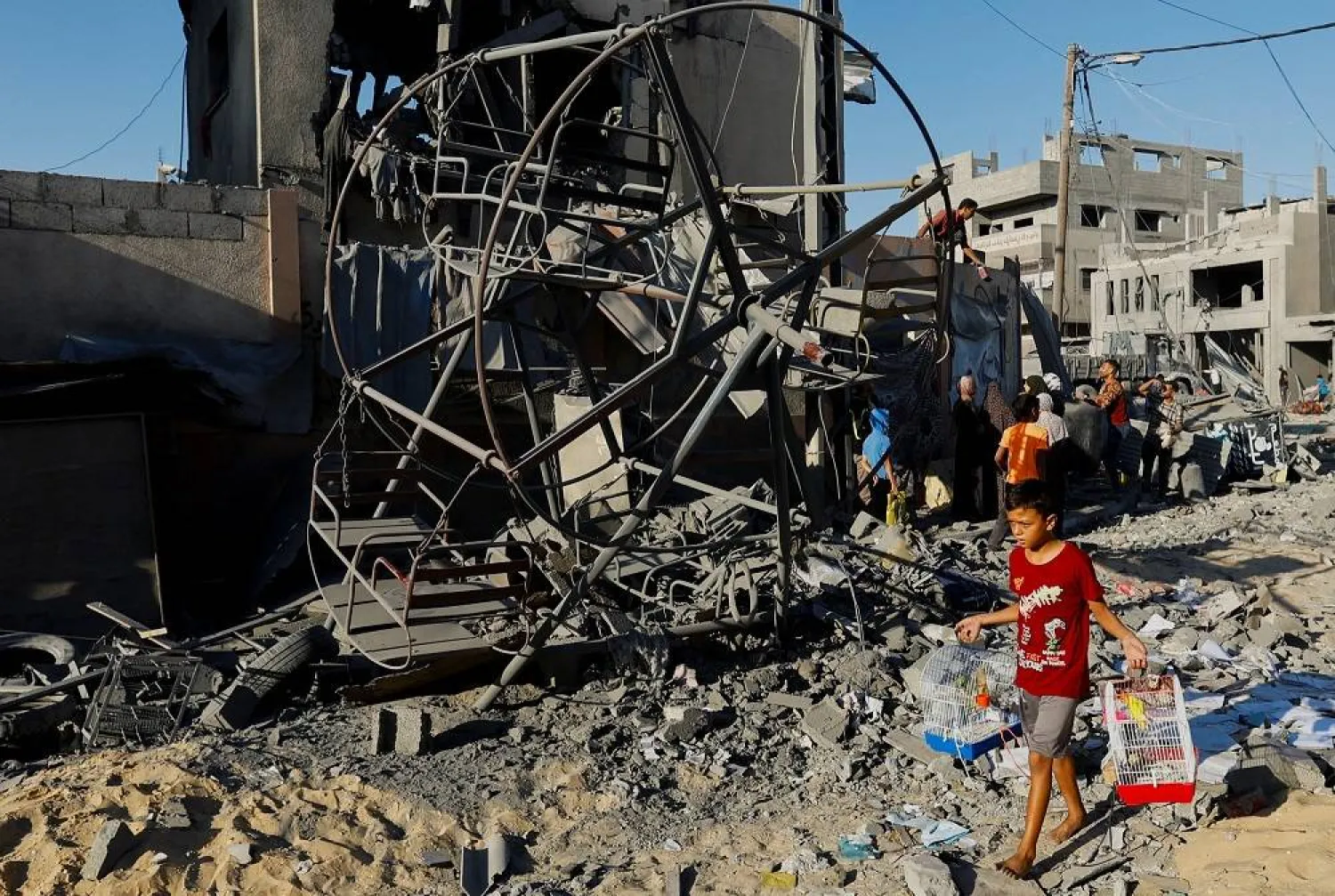 A child walks past as Palestinians inspect a site of Israeli strikes on buildings in Khan Younis in the southern Gaza Strip, October 18, 2023. (Reuters)