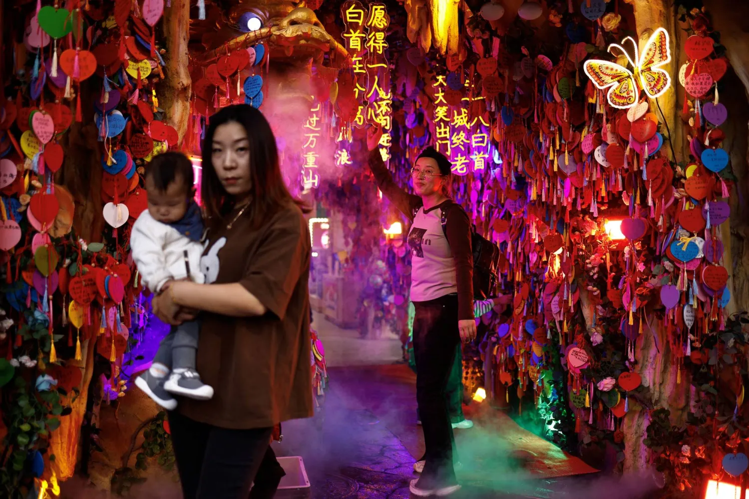 أشخاص يقفون لالتقاط الصور في مَعلم سياحي في بكين (رويترز)