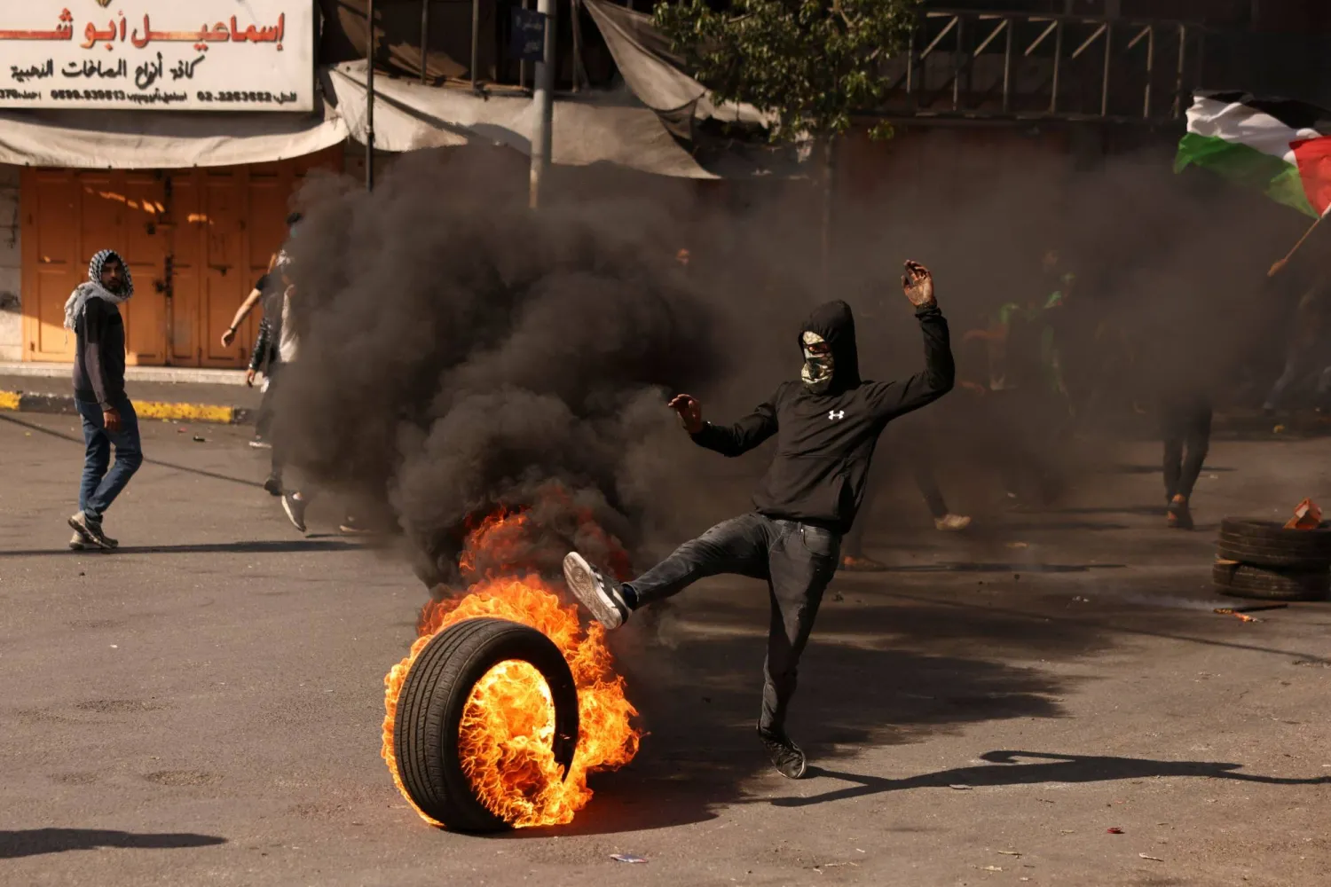 إحراق إطارات خلال احتجاجات في الخليل بالضفة الغربية اليوم الأربعاء (أ.ف.ب)